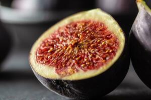 A few figs in a black bowl on an dark concrete table photo