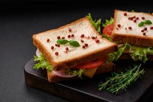 Delicious sandwich with toast, ham, tomatoes, cheese and lettuce photo