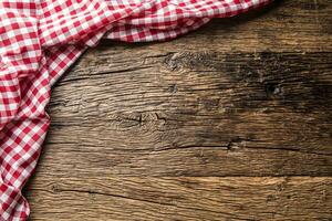 Red checkered kitchen tablecloth on rustic wooden table photo