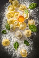 Raw ravioli with flour egg musrooms and and spinach - Top of view. Italian or mediterranean healthy cuisine photo
