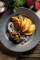 Baked homemade potato pies, creamy garlic dip, baked beetroot and roasted bacon - Top of view photo