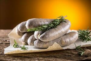 Sausages. Raw pork sausages on oak wooden table photo