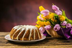 Pascua de Resurrección pastel. tradicional anillo mármol pastel con Pascua de Resurrección decotación Pascua de Resurrección huevos y primavera tulipanes foto