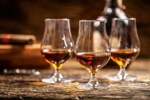 Caribbean rum in modern glasses with a bottle of rum and a cigar in the background photo