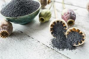 Poppy seed with their heads on wooden boards photo