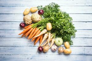 Top of view assortment fresh vegetables on wooden table photo