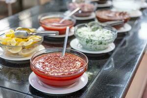 dulce chile salsa y varios apósitos en un buffet mesa en un jardín restaurante foto