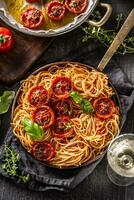 Italian pasta spaghetti with roasted tomatoes basil oregano thyme and white vine photo