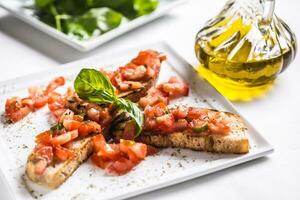 Tasty italian appetizer bruschetta on plate with olive oil photo