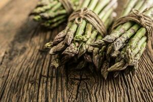 Fresh green asparagus on old oak table photo