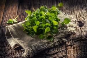 Naturally green melissa herbs on rustic jute or flax napkin folded on dark wood photo