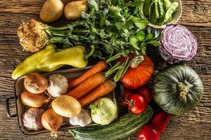 Assortment of fresh vegetables in a basket on a wooden table photo