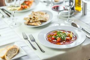 perfectamente conjunto mesa en un italiano restaurante con carpaccio, Bruschetta, y Pizza plano un pan como aperitivos foto