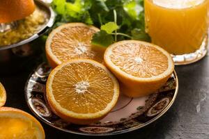Fresco naranjas exprimidor jugo tropical frutas y hierbas en hormigón tablero foto