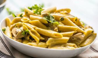 Pasta pene with chicken pieces mushrooms parmesan cheese sauce and herb decoration. Pene con pollo - Italian or medierranean cuisine photo