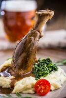 Lamb shank.Confit lamb shank with mashed potatoes spinach and draft beer in pub or restaurant photo