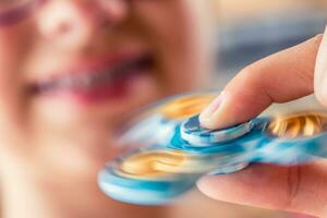 Fidget Spinner. Cute young girl playing with fidget spinner. photo