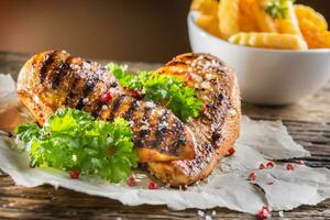 Grill chicken breast salt pepper parsley herbs and french potato fries photo