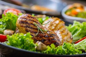 Grill Chicken Breast. Roasted and grill chicken breast with lettuce salad tomatoes and mushrooms photo