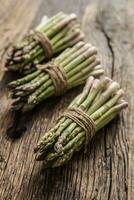 Fresh green asparagus on old oak table photo