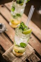 Mojito. Alcoholic cocktail drink mojito on wooden board in pub or sestaurant photo