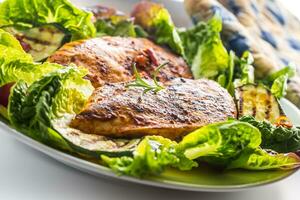 pollo mama. parrilla pollo pecho con lechuga ensalada calabacín y rábano foto