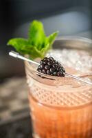 Cocktail drink bramble with black berries and mint at barcounter in night club or restaurant photo