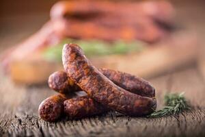 Sausages. Smoked Sausages. Chorizo sausages with vegetable rosemary spices and kitchen utensil. photo