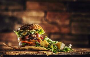 Home made tasty burger with bacon onion cheese ane lettuce on wooden box photo