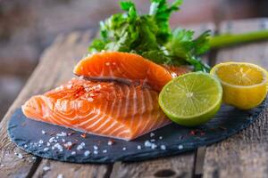 Raw salmon fillets with parsley herbs lime lemon salt and dried saffron photo