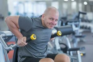 Young muscular man or trainer exercising in gym photo