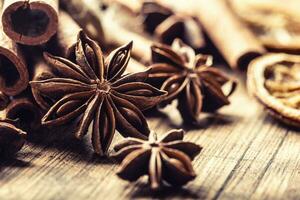Detail of star anize and cinnamon sticks on a vintage wooden surface photo