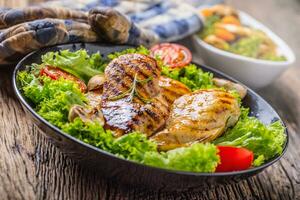 Grill Chicken Breast. Roasted and grill chicken breast with lettuce salad tomatoes and mushrooms photo