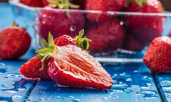 Fresh ripe strawberries washed with water on blue table photo