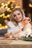 joven hermosa mujer en un Navidad atmósfera participación un taza con café o té foto