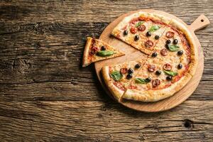 Top of wiew italian pizza on wooden plate and round board photo