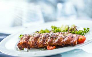 A la parrilla parilla Cerdo costillas en un blanco plato como menú en pub. foto