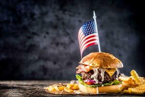 de cerca hogar hecho carne de vaca hamburguesa con americano bandera y papas fritas en de madera mesa foto