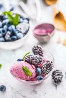 Blueberry and blackberry ice cream in bowl with frozen fruits photo