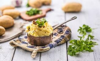 Mashed potatoes in pan decorated with parsley herbs. photo