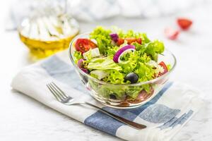 Spring vegetable salad with tomatoes onion cheese and olives. photo