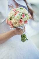 Wedding bouquet. Bride holding her wedding bouquet with roses photo