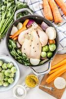 Chicken ready to cook broth with fresh root vegetables and spices photo