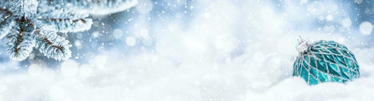 Blue christmas ball on snow with fir branches. Merry Xmas concept - panoramic banner photo