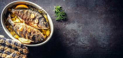 Roasted mediterranean fish bream with potatoes rosemary and lemon photo