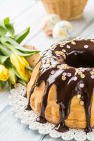 delicioso fiesta eslovaco y checo pastel babovka con chocolate vidriar. Pascua de Resurrección decoraciones - primavera tulipanes y huevos foto