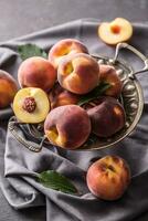 A group a ripe peaches in rustic bowl photo