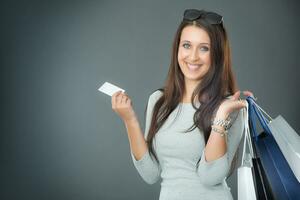 retrato de joven contento sonriente mujer con compras pantalones crédito tarjeta y zapatos. foto