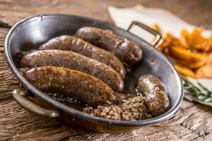 Sausages.Roasted pork sausage in a pan with potatoes and rosemary. photo