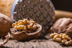Walnut. Walnut kernels and whole walnuts on rustic old oak table photo
